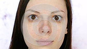 Young brunette woman looking at the camera. Eyes and nose close-up.