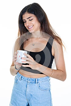 Young brunette woman looking holding hot cup of coffee mug