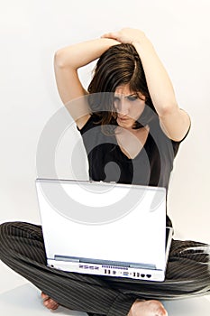 Young brunette woman perplexed by computer