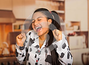 Young brunette woman posing in pyjamas, interacting with camera by stretching and yawning