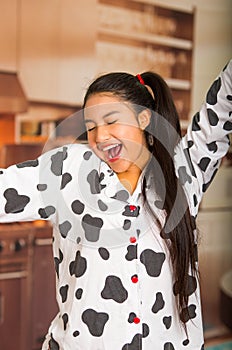 Young brunette woman posing in pyjamas, interacting with camera by stretching and yawning