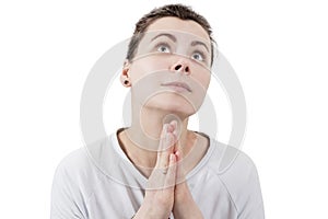 Young brunette woman praying to God and palms together in front of face isolated on white background