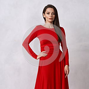 Young brunette woman in red evening dress