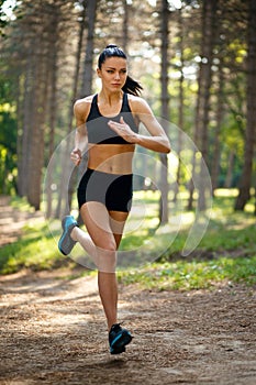 Young brunette woman running in park, healthy, perfect fit tone body. Workout outside. Lifestyle concept