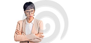 Young brunette woman with short hair wearing business jacket and glasses skeptic and nervous, disapproving expression on face with