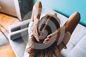 Young brunette woman showing her hair, hair roots, hair loss or dry scalp