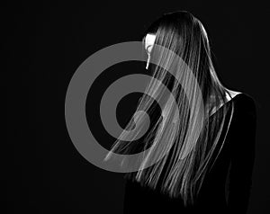 Young brunette woman shows her luxurious healthy recovered long straight hair. Black and white