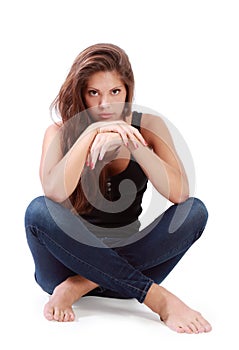 Young brunette woman sits on floor with bended knees