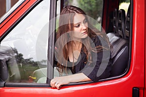 Young brunette woman sitting in car and driving backwards