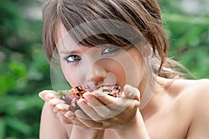 Young brunette woman smelling dried flowers