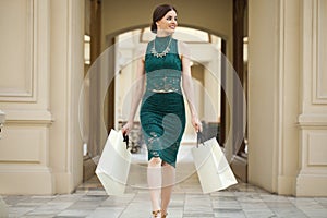 Young brunette woman with some shopping bags in the mall