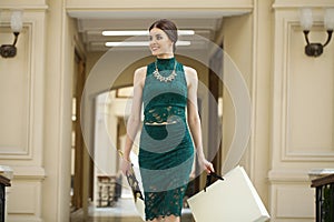 Young brunette woman with some shopping bags in the mall