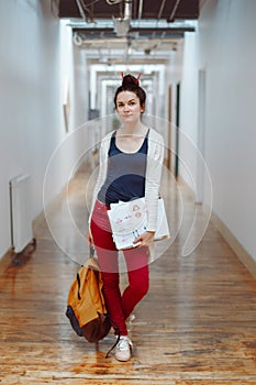 young brunette woman student, female drawing designer artist, in hall of college university, person at work