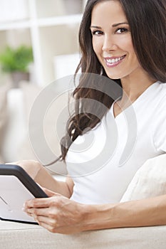 Young Brunette Woman Using Tablet Computer At Home