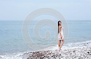 A young brunette woman walking near the sea