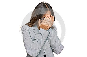 Young brunette woman wearing business clothes with sad expression covering face with hands while crying