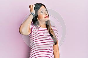 Young brunette woman wearing casual clothes over pink background confuse and wondering about question