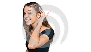 Young brunette woman wearing casual clothes smiling with hand over ear listening an hearing to rumor or gossip