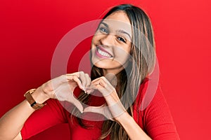 Young brunette woman wearing casual clothes smiling in love doing heart symbol shape with hands