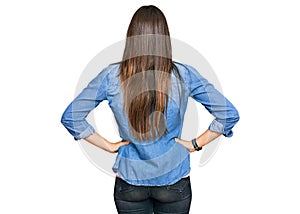 Young brunette woman wearing casual clothes standing backwards looking away with arms on body