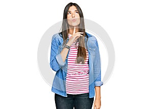 Young brunette woman wearing casual clothes thinking concentrated about doubt with finger on chin and looking up wondering