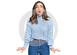 Young brunette woman wearing casual winter sweater afraid and shocked with surprise and amazed expression, fear and excited face