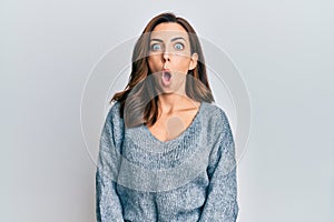 Young brunette woman wearing casual winter sweater afraid and shocked with surprise expression, fear and excited face