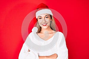 Young brunette woman wearing christmas hat happy face smiling with crossed arms looking at the camera