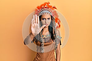 Young brunette woman wearing indian costume doing stop sing with palm of the hand