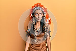 Young brunette woman wearing indian costume making fish face with lips, crazy and comical gesture