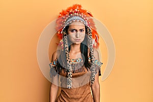 Young brunette woman wearing indian costume puffing cheeks with funny face