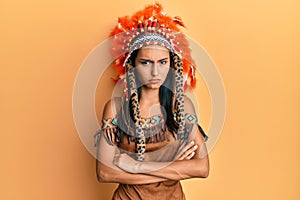 Young brunette woman wearing indian costume skeptic and nervous, disapproving expression on face with crossed arms