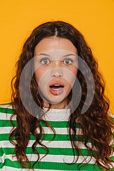 Young brunette woman wearing t-shirt expressing surprise at camera