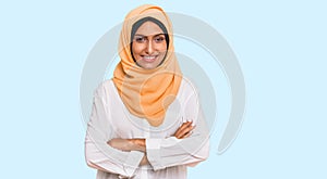 Young brunette woman wearing traditional islamic hijab scarf happy face smiling with crossed arms looking at the camera