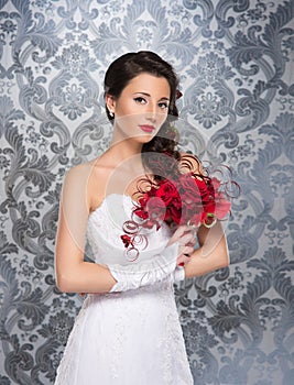 A young brunette woman in a white bridal dress