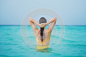 Young brunette woman in yellow one piece swimsuit.