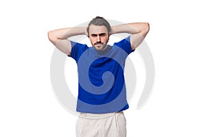 a young brutal European man with black hair and a beard dressed in a blue T-shirt against the background of copy space