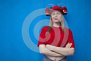 Young brutal girl fan is standing confidently on a blue background