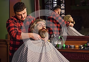 Young and brutal. handsome hairdresser cutting hair of male client. Hairstylist serving client at barbershop. Personal