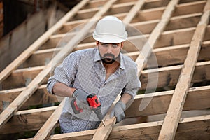 The young builder works on an unfinished roof