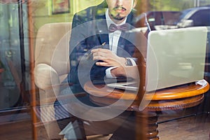 Young businesman working at cafe, using laptop