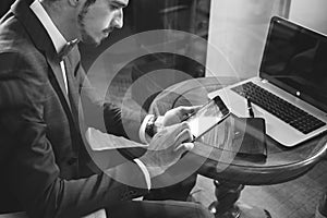 Young businesman working at cafe, using mobile phone