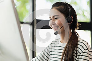 Young business asian woman working call centre customer service agents. Business female support operator with computer and headset