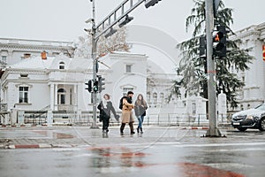 Young business colleagues walking together outdoors on a snowy city day.