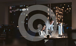 Young business colleagues working overtime together at an office desk