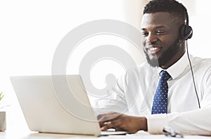 Young business consultant typing email to client on laptop