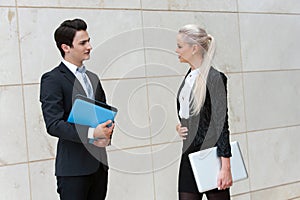 Young business couple with file and laptop.