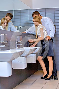 Young business couple flirting with each other at office washroom