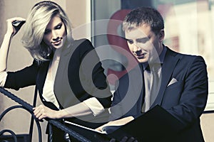 Young business couple with a folder against office window