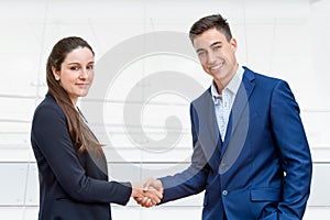 Young business couple shaking hands.